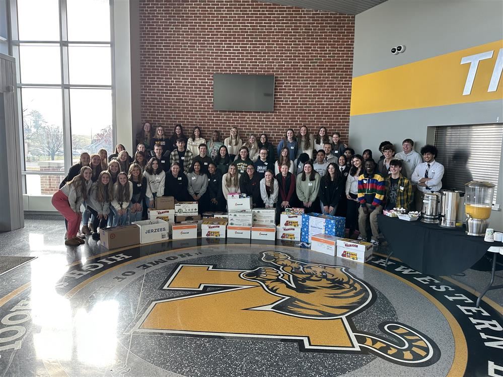  A large group is student and teachers gather for a group photo.